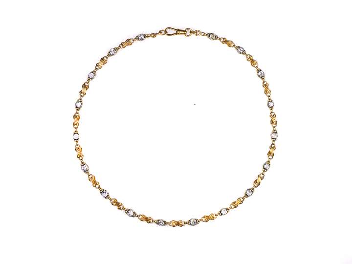 Antique gold and diamond chain necklace, 18 cushion cut diamond collets with stylised figure-of-eight gold scroll sections between